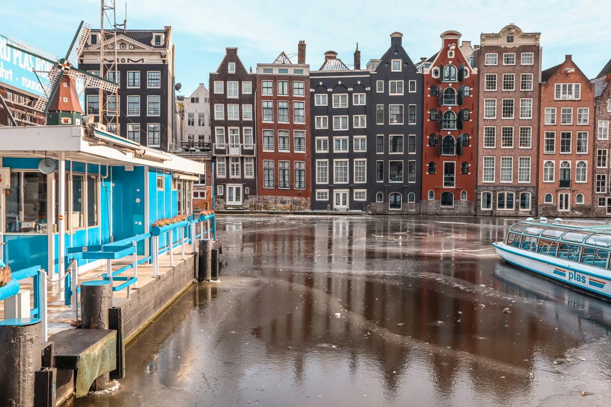 Thin ice on the Damrak in Amsterdam, in front of a row of canal houses
