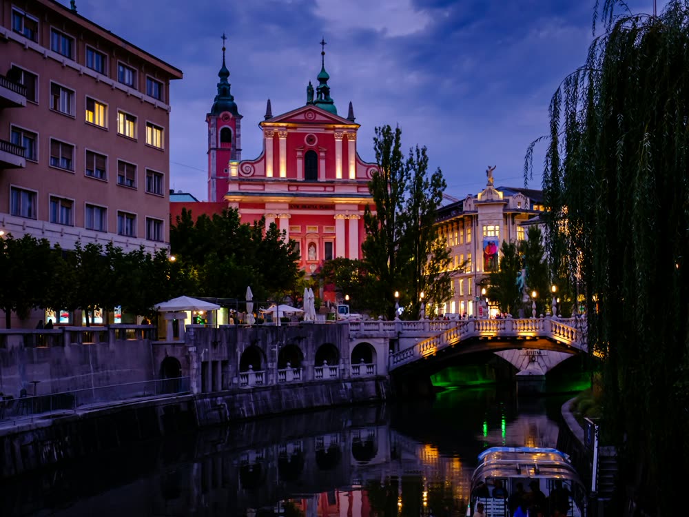 The Triple Bridge and Franciscan Church in Ljubljana at dusk